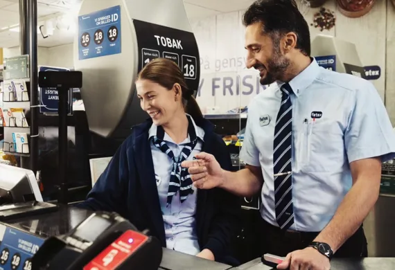 Smilende kvinde og mand der arbejder i kassen i Føtex
