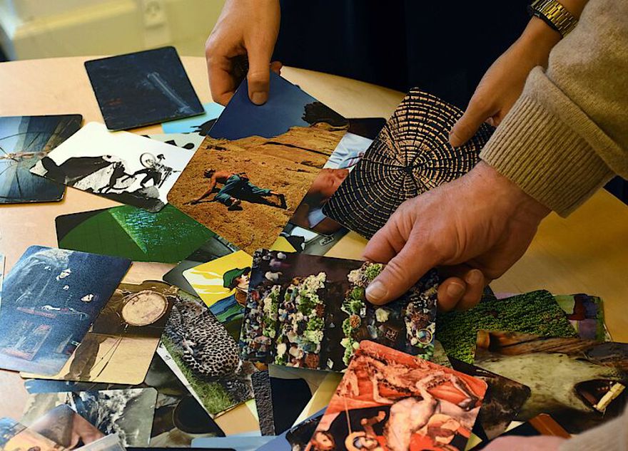 Hænder som sorterer fotos på et bord
